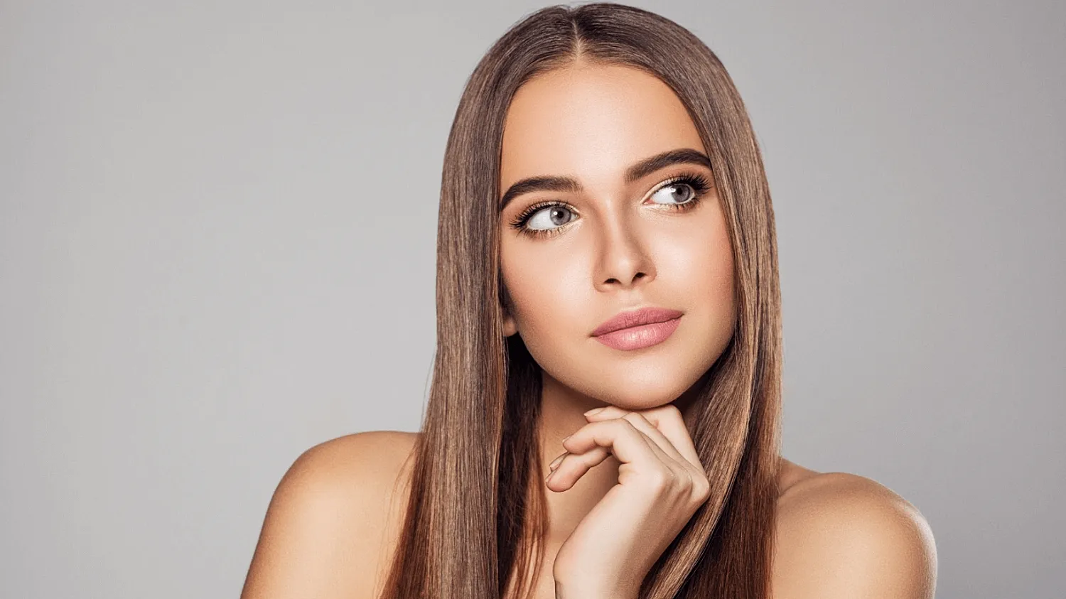 Young woman with long hair and thoughtful expression.
