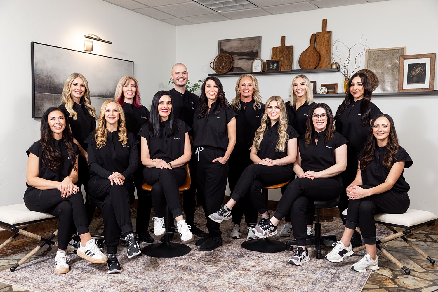 Three women in matching black outfits posing together.