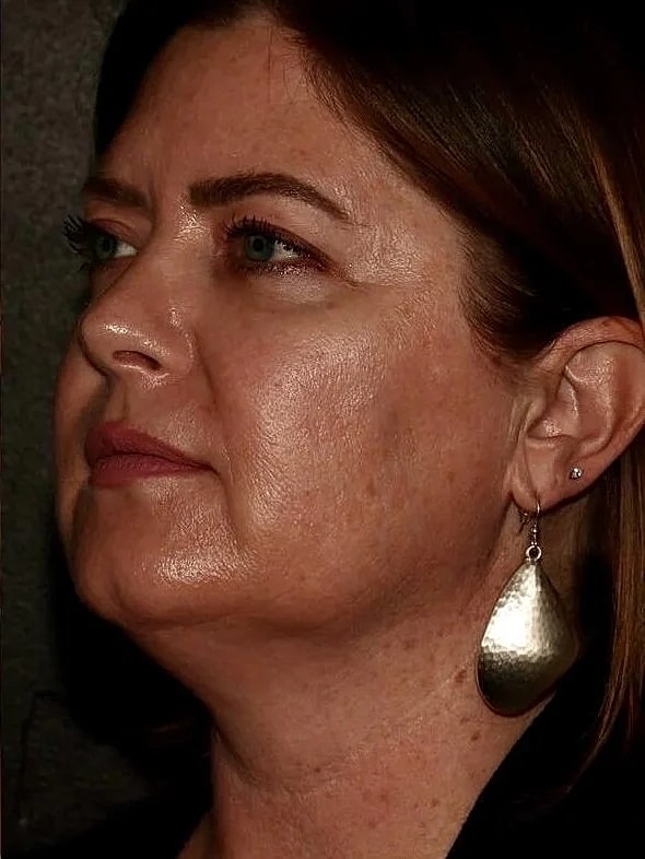 Profile of woman with earrings and natural makeup.