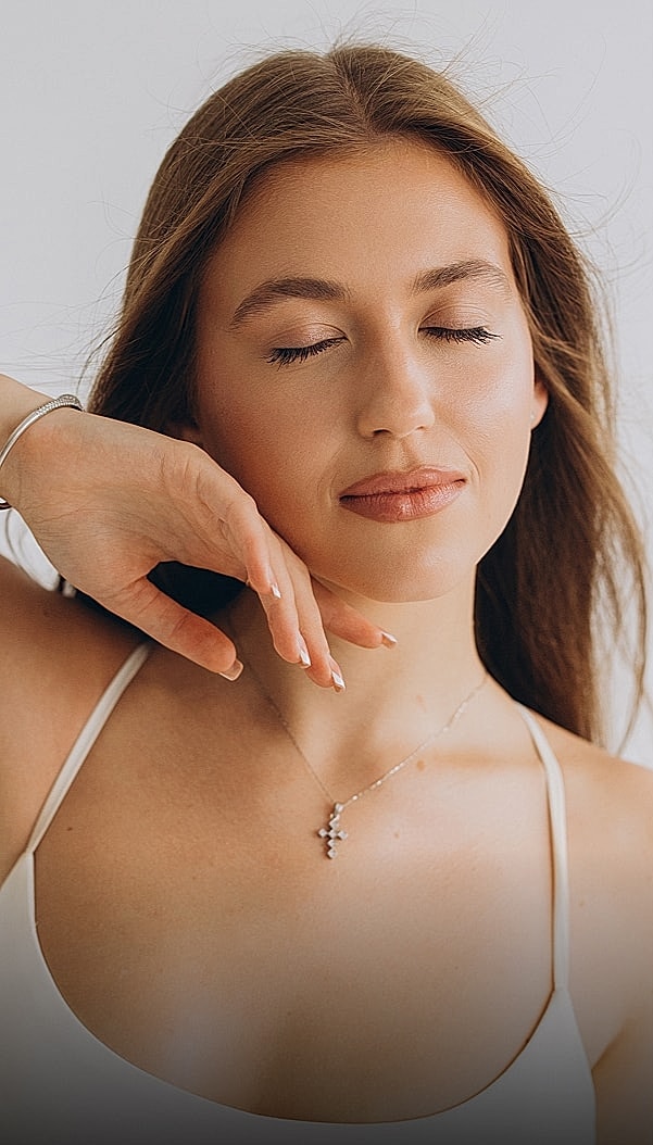 Woman posing with closed eyes and delicate jewelry.