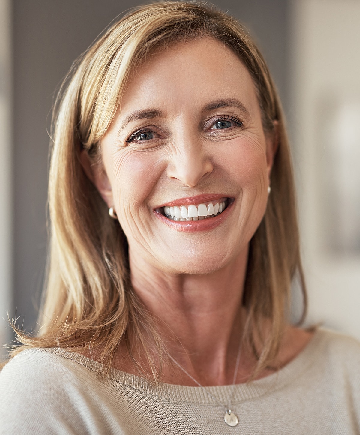 Smiling woman with blonde hair in casual attire.