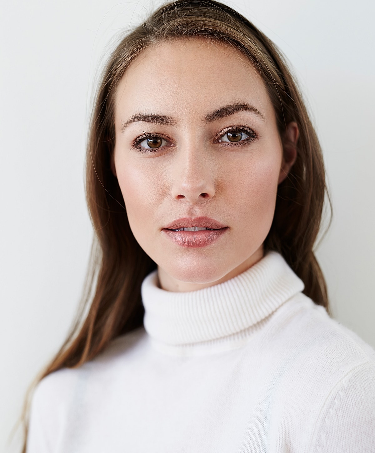 Close-up of woman with natural makeup and sweater.