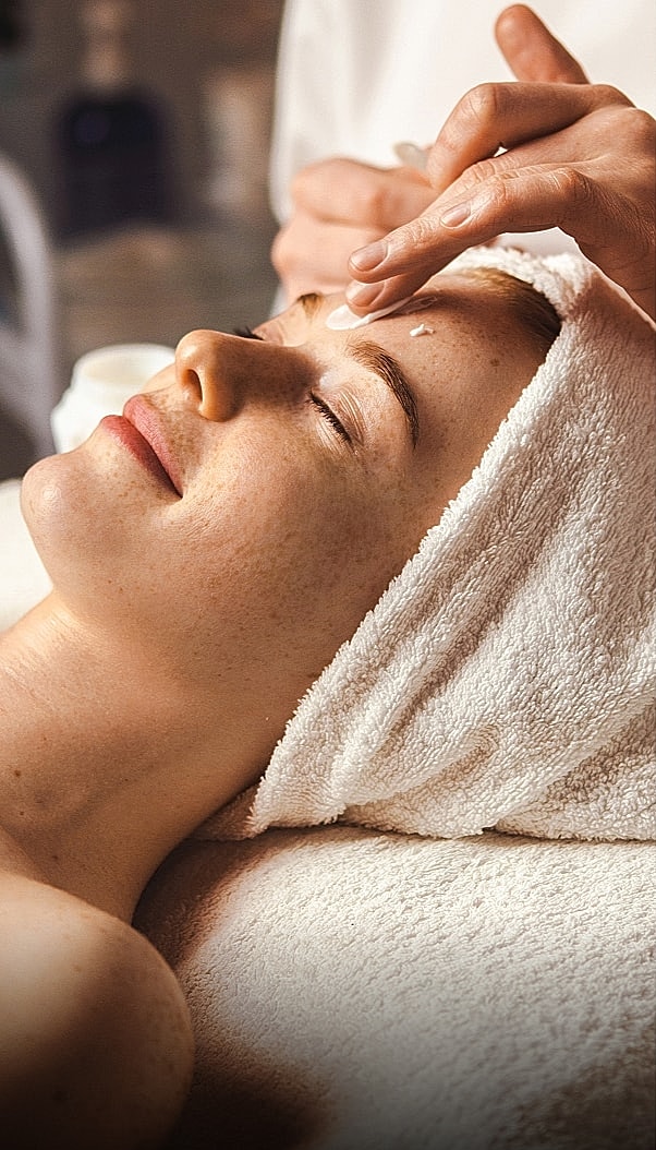 Woman receiving a facial treatment in spa setting.