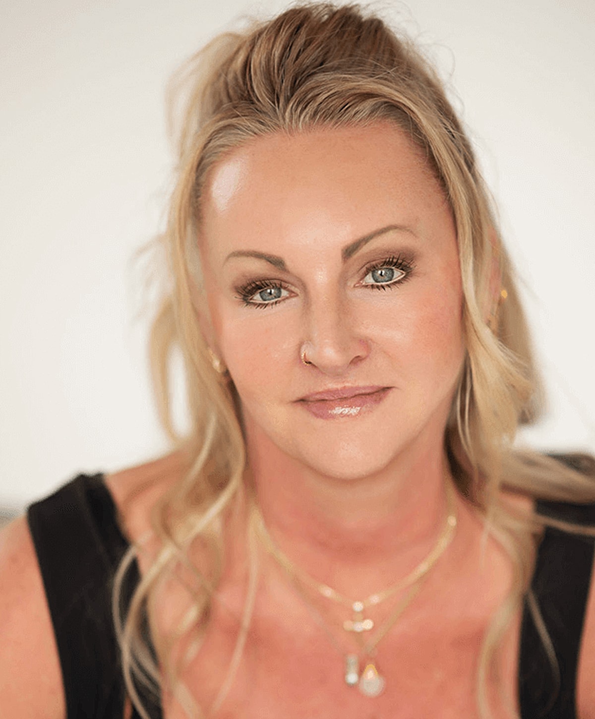 Woman with long blonde hair and necklace.