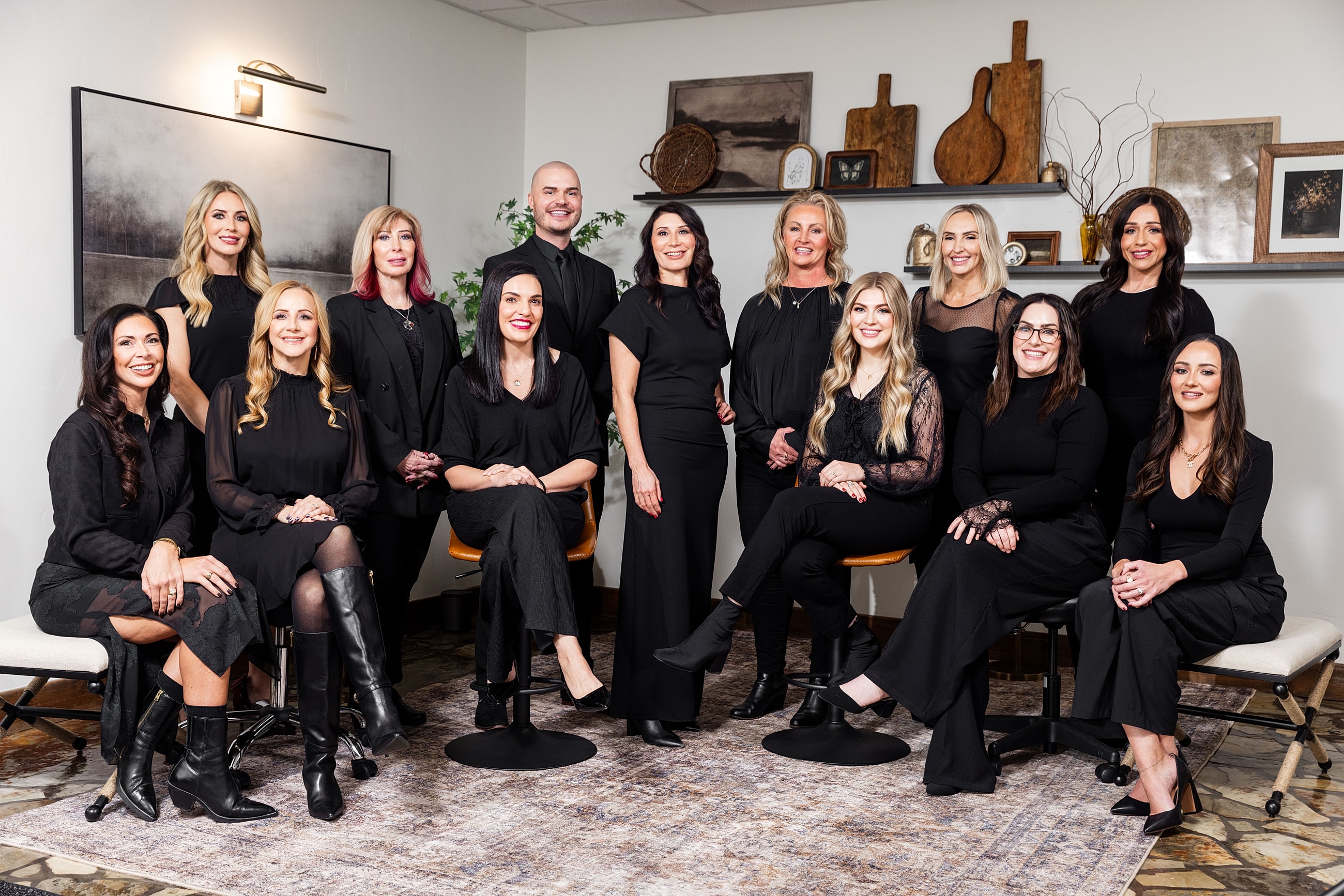 Three women smiling in black outfits.