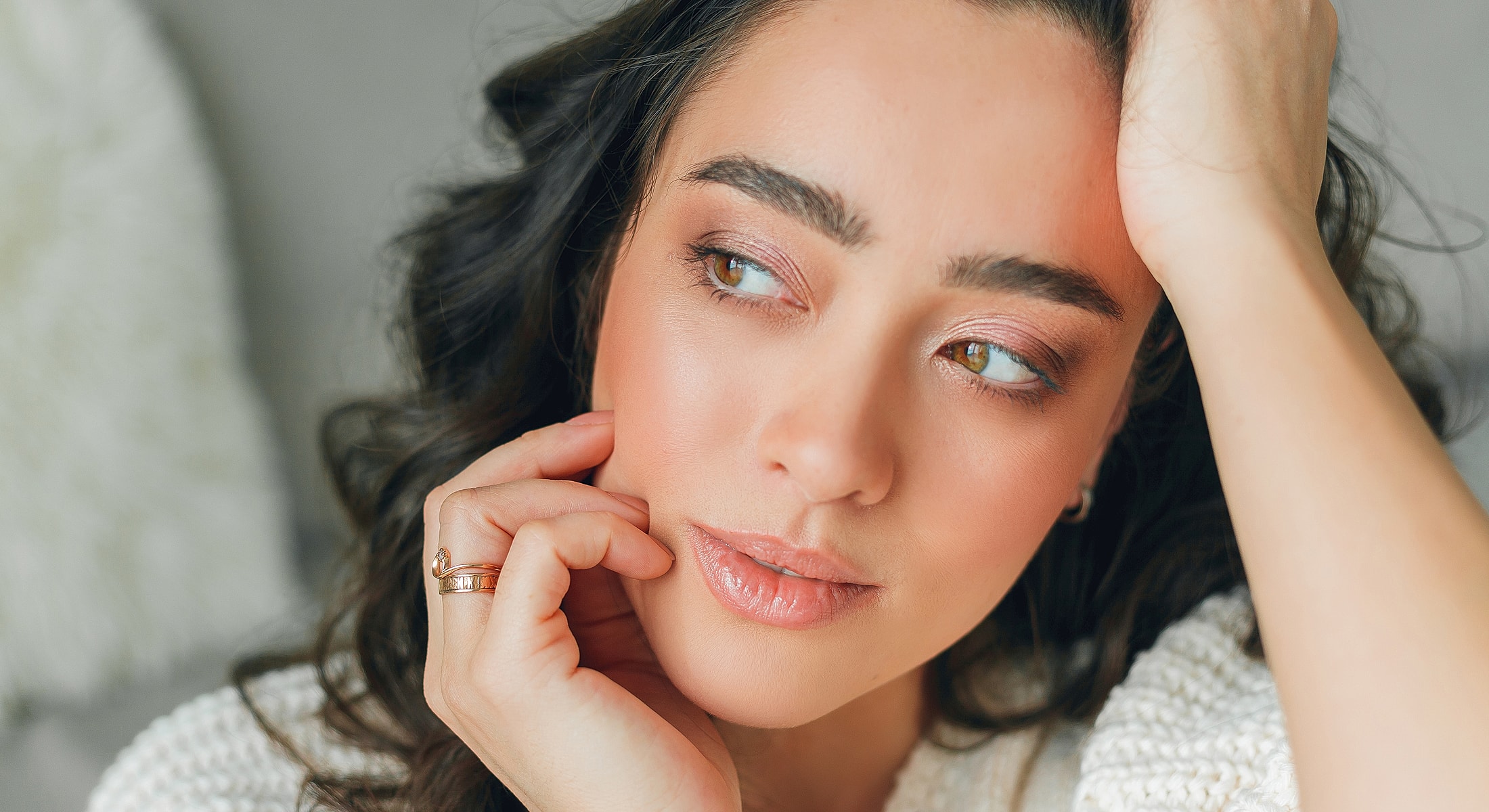 Woman with soft makeup and curly hair.